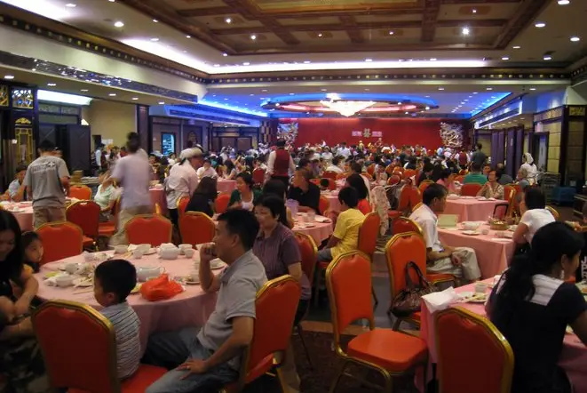 Jing Fong banquet hall in pre-pandemic times, showing tables of customers eating in a large room.